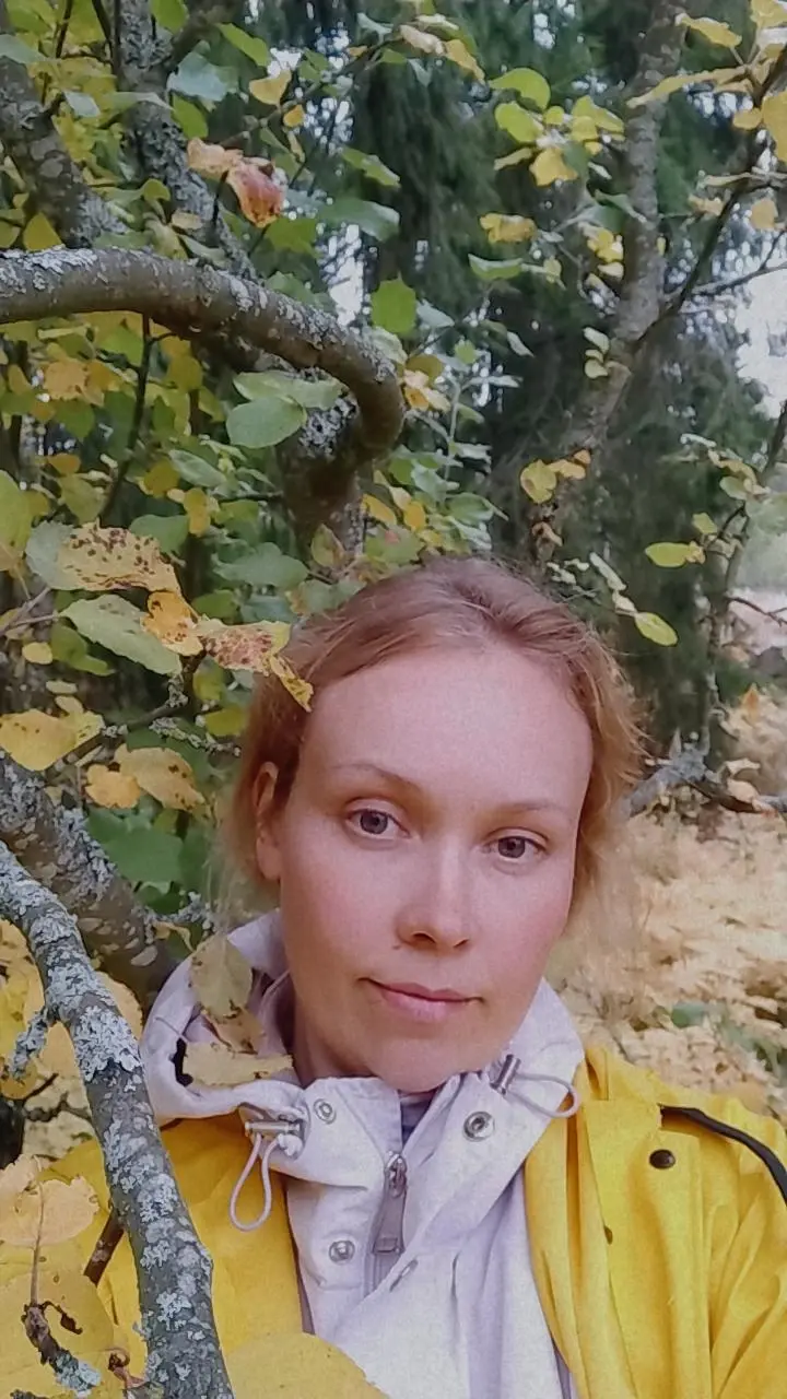 Keltatakkinen nainen metsässä