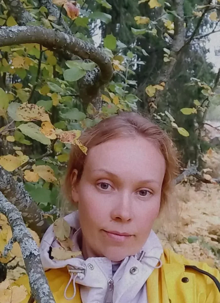 Keltatakkinen nainen metsässä